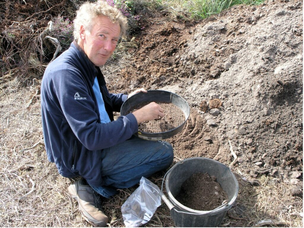 Man digging beside bucket